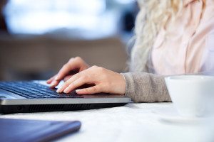 Woman Writes A Review Using Her Laptop